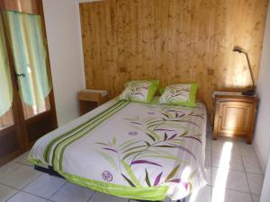 a bedroom with a bed with green and purple sheets at Rez de Jardin Guillestre in Guillestre