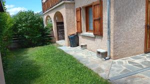 a building with a grass yard next to a house at Rez de Jardin Guillestre in Guillestre