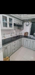 a kitchen with white cabinets and a counter top at Jannat Villa in Dhaka