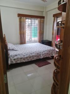 a bedroom with a bed and a window at Jannat Villa in Dhaka