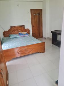 a bedroom with a wooden bed in a room at Jannat Villa in Dhaka +2 photos