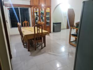 a dining room with a wooden table and chairs at Jannat Villa in Dhaka