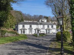 a white house with a street light in front of it at Valley Lodge - Uk49228 in Gunnislake +25 photos