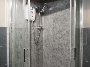 a shower in a bathroom with a glass door at Fairhead Cottage in Grosmont