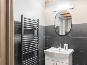 a bathroom with a sink and a mirror at Fairhead Cottage in Grosmont