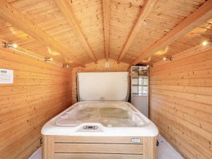 een sauna met een witte kuip in een houten kamer bij Duck Bay Cottage 2 - Uk43935 in Balloch