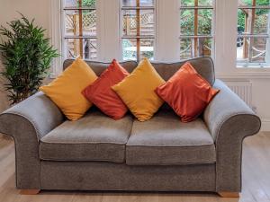 a gray couch with four colorful pillows on it at The Haven Lodge in Clifton