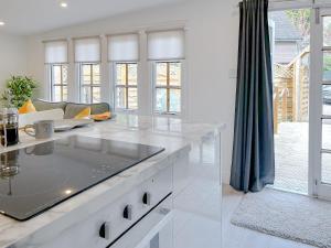 a white kitchen with a couch and a table at The Haven Lodge in Clifton +10 photos