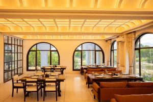 un ristorante con tavoli, sedie e finestre di Still River Suites by ELIVAAS a Thūr