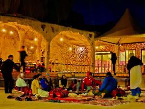 a group of people sitting on the floor in a cave at NAEL BEDOUIN Camp in Wadi Rum