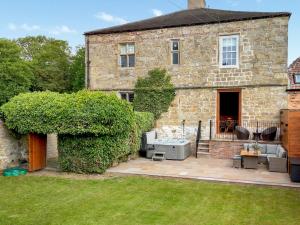 a large stone house with a patio in front of it at Killerby Old Hall - Uk47711 in Cayton