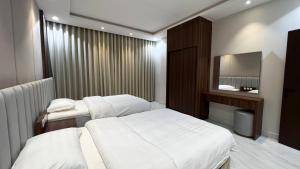 een hotelkamer met twee bedden en een spiegel bij متسع للشقق المخدومة in Hail +10 foto's