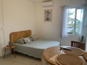 a small bedroom with a bed and a table at O kAZ de Petite île in Petite Île +20 photos