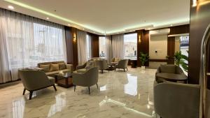 een hotellobby met banken, stoelen en ramen bij متسع للشقق المخدومة in Hail