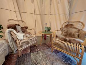 KvillsforsHemma fran Hemma - Glamping的两个泰迪熊坐在一个房间里椅子上