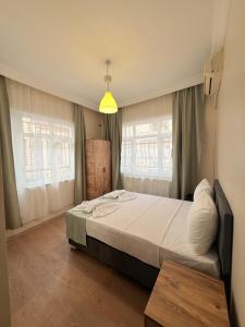 a bedroom with a bed and two windows at walkabout apart in Istanbul