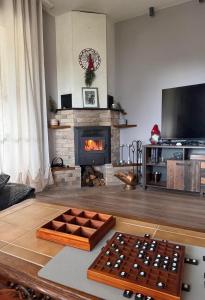 een woonkamer met open haard en een tafel bij Къща за гости В 12 и 5 in Dolna Banya