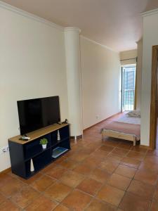 un soggiorno con TV a schermo piatto e divano di Old Zone Apartment - 1º B a Bicas 1 altra foto