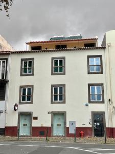 un edificio bianco con quattro porte e un idrante antincendio di Old Zone Apartment - 1º B a Bicas