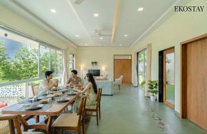 a group of people sitting around a dining room table at EKOSTAY - Alpine Villa in Alibaug