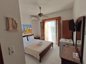 una camera con letto e televisore di Avlonitis Rooms a Párga