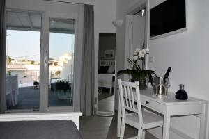 ein Wohnzimmer mit einem weißen Tisch und einem weißen Stuhl in der Unterkunft Arneo Terra del Sole B&B in Torre Lapillo + 45 Fotos