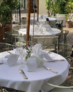 a group of tables with white tablecloths and silverware at Hotel Zur Post in Egna +11 photos