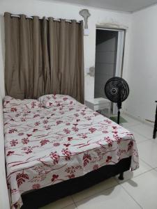 a bedroom with a bed with a red and white blanket at Casa Praça in Paripueira