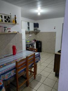 a kitchen with a table and a counter top at Casa Praça in Paripueira