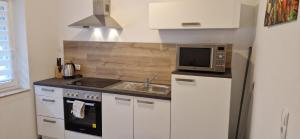 a small kitchen with a sink and a microwave at Sson-Appartments in Detmold +17 photos