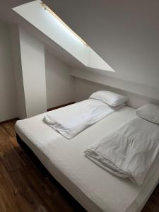 a bed with white sheets and pillows in a room at Apartman Lapaž 12 in Toplice Sveti Martin