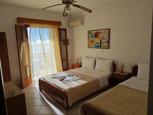 una camera d'albergo con due letti e una finestra di Avlonitis Rooms a Párga