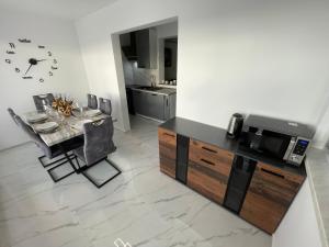 a kitchen and dining room with a table and a microwave at Second home apartment - gold in Kustići