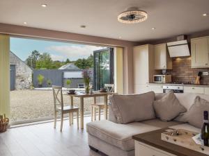 a kitchen and living room with a couch and a table at Brook View Cottage in Pembrokeshire