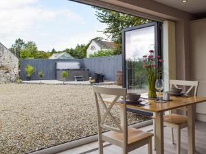 a patio with a table and chairs and a garden at Brook View Cottage in Pembrokeshire +10 photos