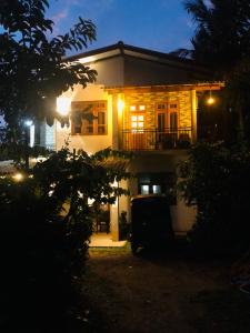 a house at night with a car parked in front at Linu Homestay in Hiriketiya