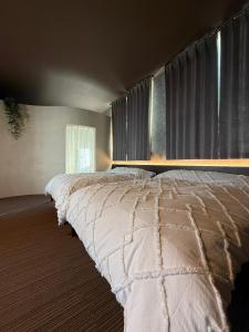 a bedroom with a large bed with a window at 欒裏町ouchi uramachi in Matsumoto