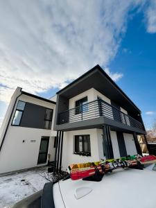 een huis met een auto ervoor geparkeerd bij Forest Lux Apartman in Odorheiu Secuiesc