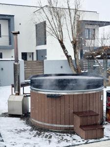 een hottub in een tuin met sneeuw op de grond bij Forest Lux Apartman in Odorheiu Secuiesc