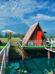 a house with a red door and a pool of water at Western View Chiangdao Camping in Chiang Dao