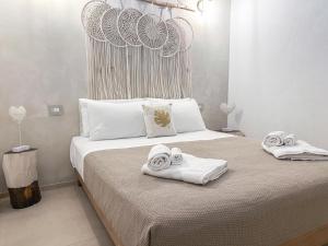 een slaapkamer met 2 handdoeken op een bed bij Palma Residence Salento in San Foca