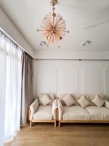 een woonkamer met een bank en een kroonluchter bij Sosun View Private Villa in Thoddoo