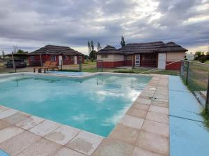 a swimming pool in a yard with two houses at Complejo Balcarce in San Rafael
