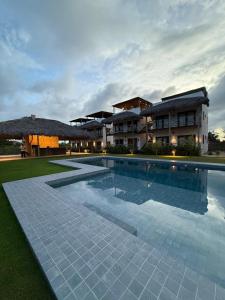 una grande piscina di fronte a un edificio di Morros da Barra chalé 05 a Barra Grande