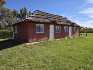 a small red house with a grass roof at Complejo Balcarce in San Rafael