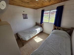a small bedroom with two beds and a window at Complejo Balcarce in San Rafael