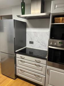 a kitchen with stainless steel appliances and a refrigerator at Gästewohnung Karin in Fjelby +9 photos