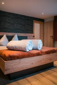 una camera da letto con un grande letto in legno con due cuscini di die Harmonie a Nauders