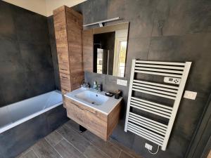 ein Badezimmer mit Waschbecken, Badewanne und Spiegel in der Unterkunft Le chalet O'Perché - Wissembourg in Wissembourg