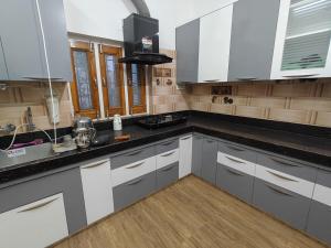 a kitchen with white cabinets and a black counter top at Bikaner House in Bikaner +22 photos